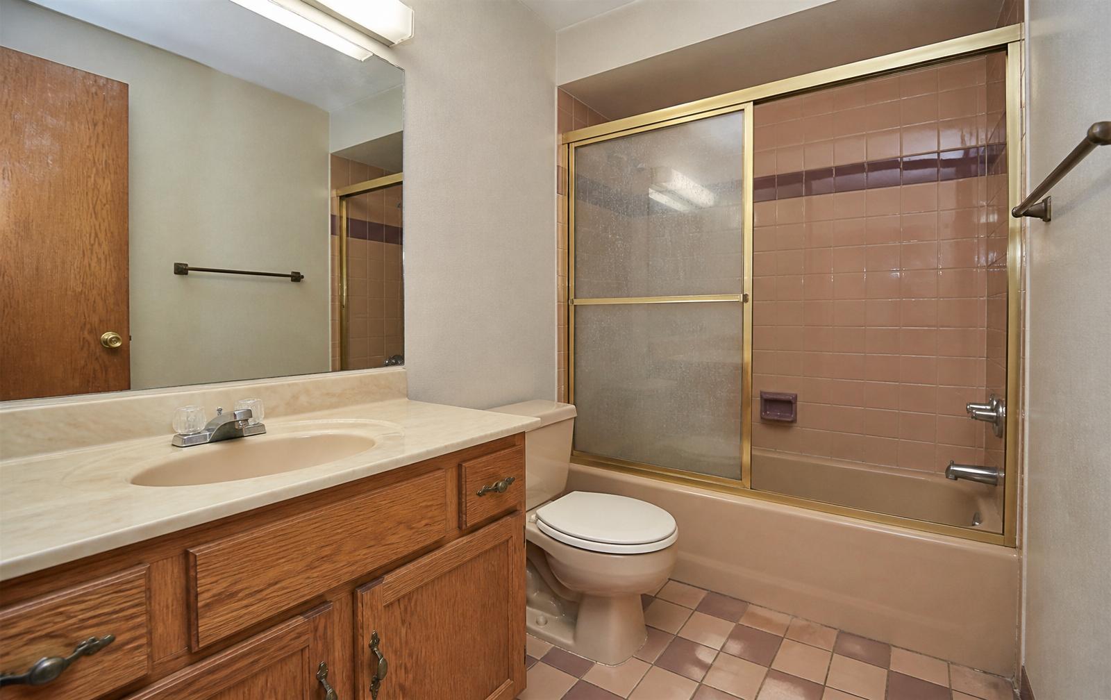 Dated peach-tile bathroom before renovation